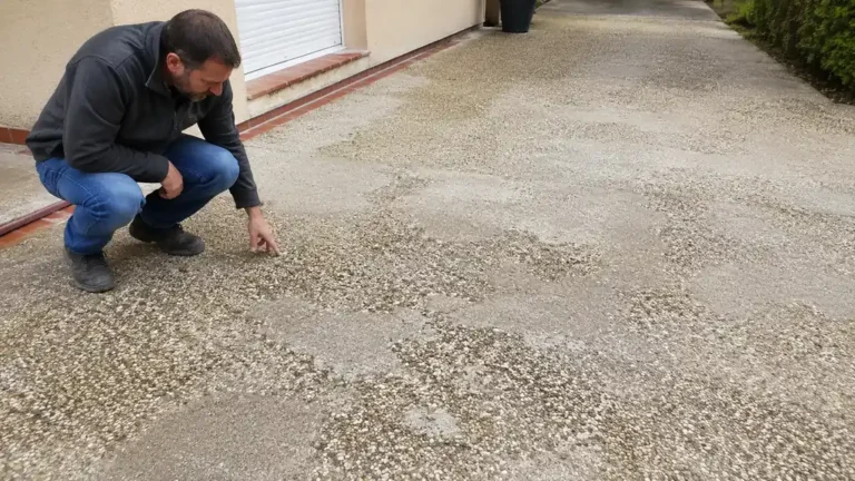 Propriétaire inspectant un béton désactivé raté présentant une surface irrégulière et des granulats mal répartis